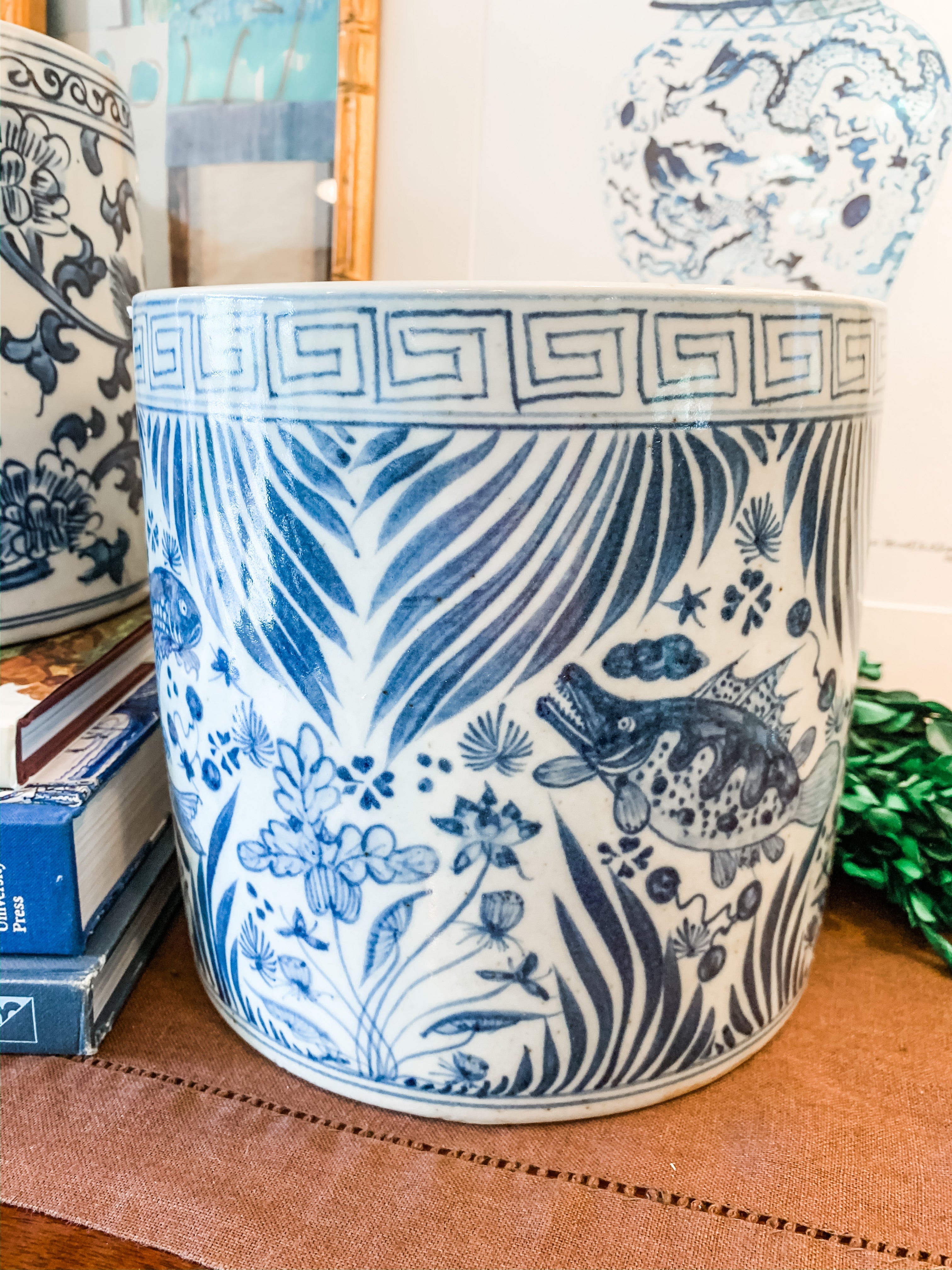 Shop Collectible Brooks for a wide variety of blue and white chinoiserie porcelain.  This is the perfect sized blue and white porcelain cache pot or planter for an orchid, your kitchen utensils, and even a wine chiller! Measures 7.5”x7.5”, hand painted with a fish and greek key design and is in new antique-style condition.